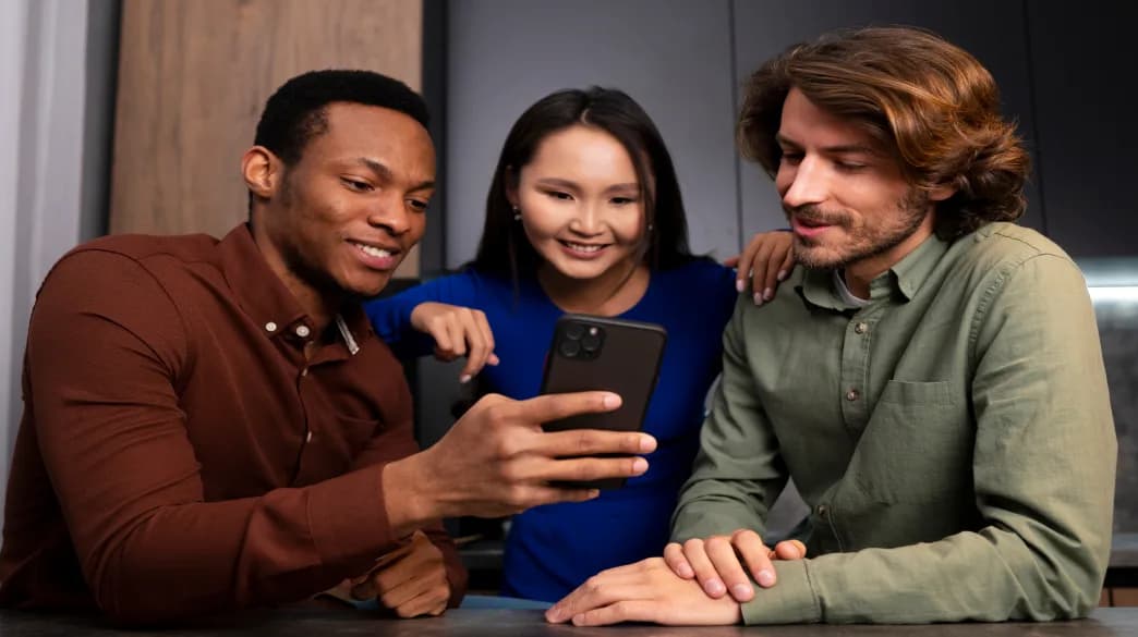 Team collaborating while reviewing a smartphone app ad on a device