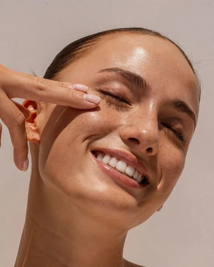 Close-up of a woman smiling during skincare routine