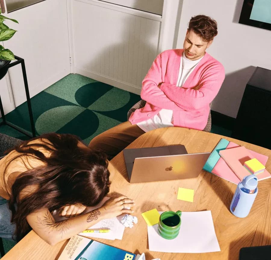 Team at a busy desk with laptop, notes, and coffee