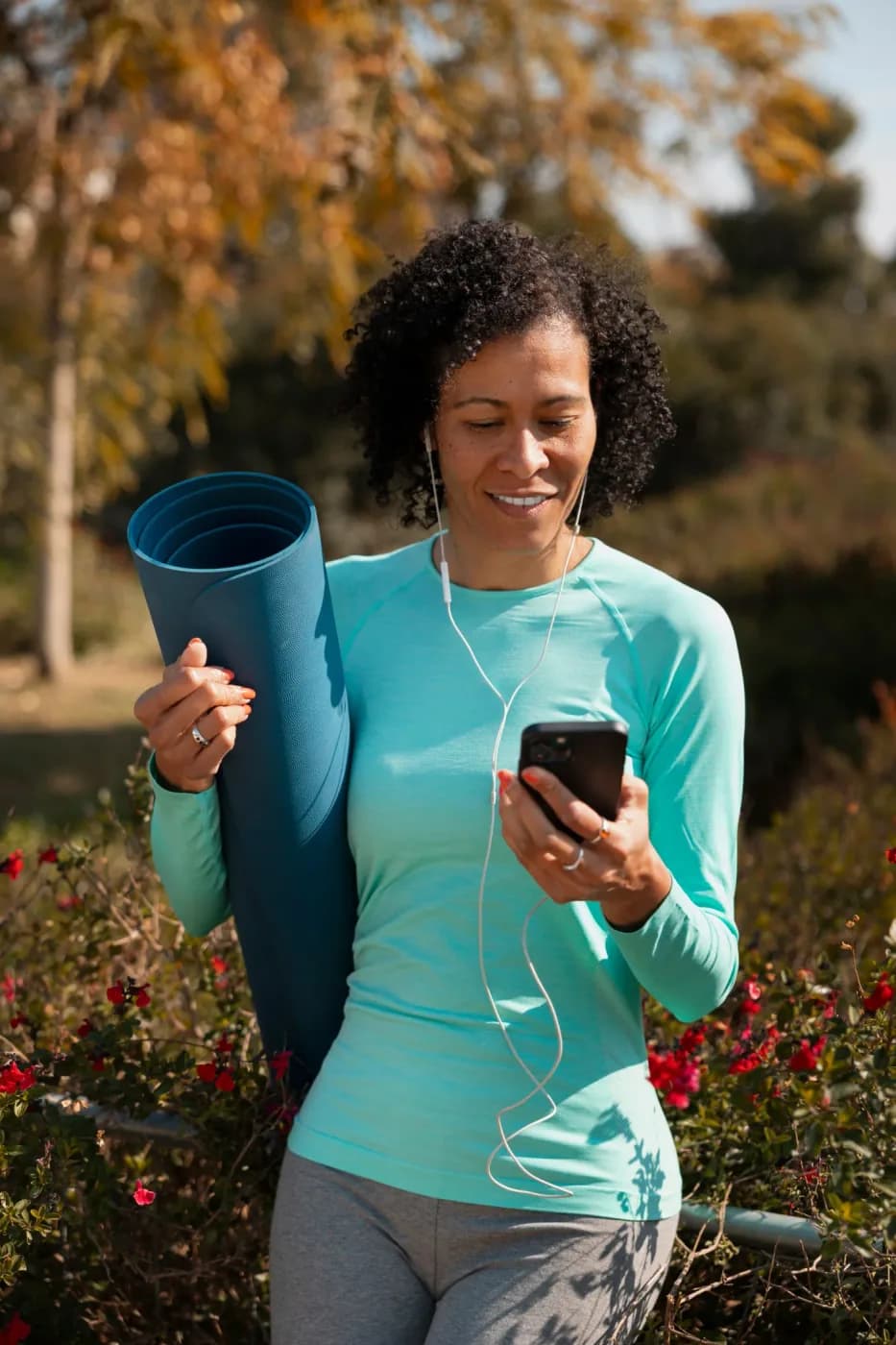 Woman with yoga mat using a health and wellness app