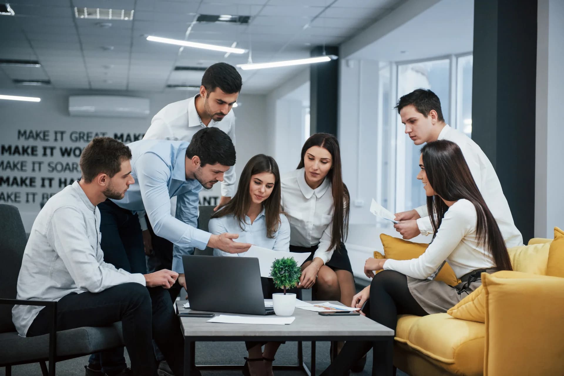 Marketing team collaborating around a computer in an office