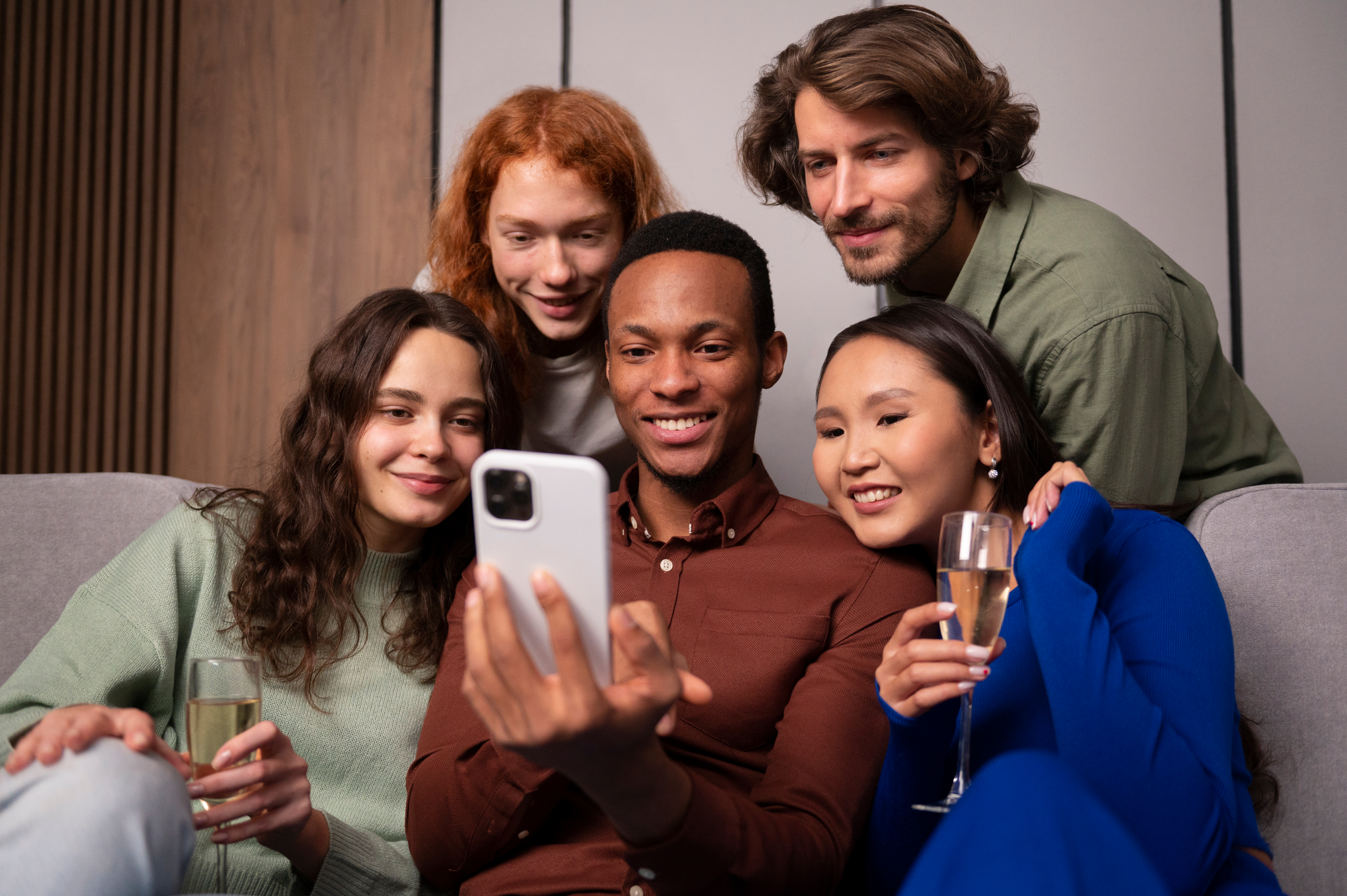 Friends gathered around a phone, sharing a moment together.