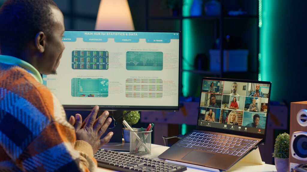 African american male freelancer attends meeting call with clients on laptop – VidAU.ai Man presenting the statistics of auto subtitle generator to audience