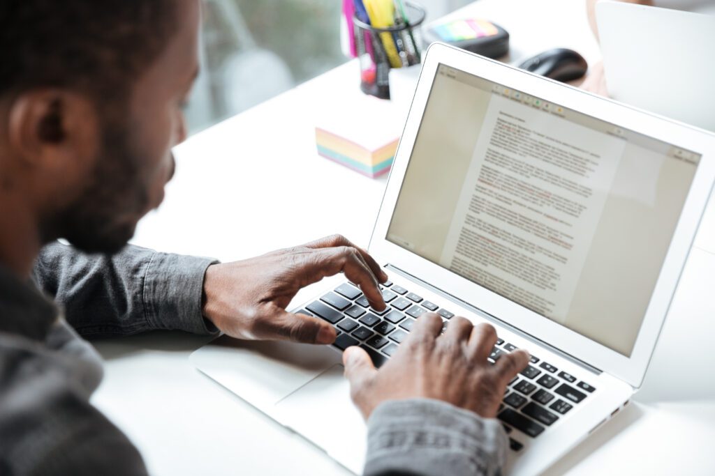 Cropped photo of serious young man sitting in office coworking – VidAU.ai Creator reading UGC video legal checklist
