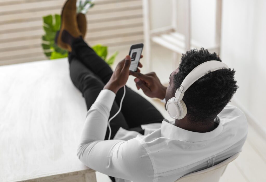 high view from shot man listening music – VidAU.ai Man using the best YouTube to MP3 converter