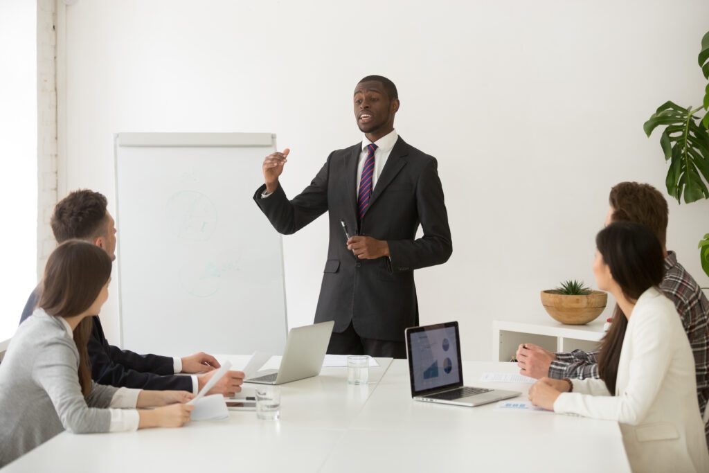 Confident african speaker or business coach giving presentation – VidAU.ai Team leader explaining how to be an ai influencer that creates viral videos.