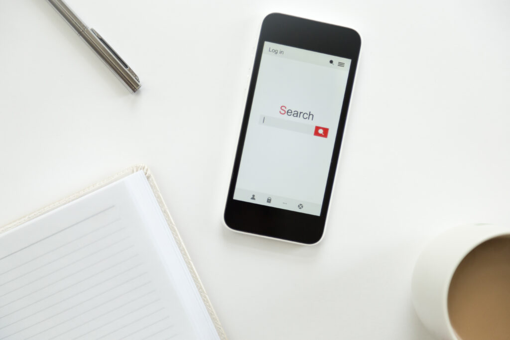 Top view of a mobile phone lying on a white office desk youtube comments search