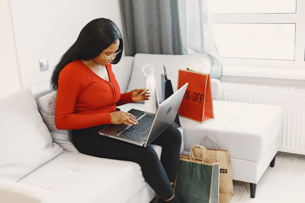 African woman online shopping at home product reviewer