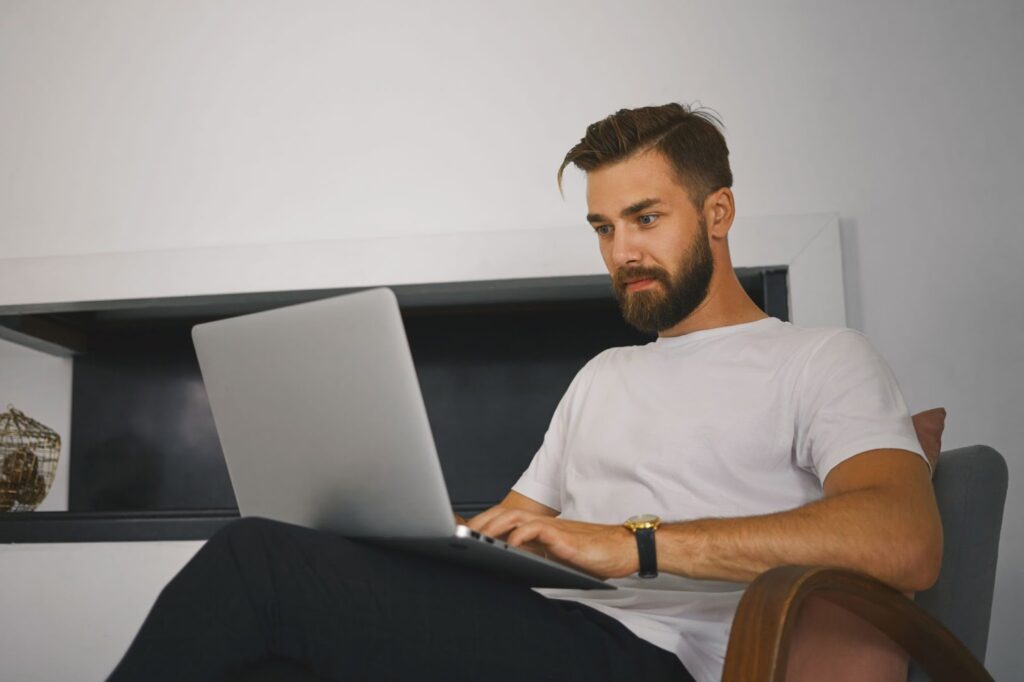 topaz video ai pro 7.1.1 – VidAU.ai A man sitting on his couch using the topaz video ai pro 7.1.1