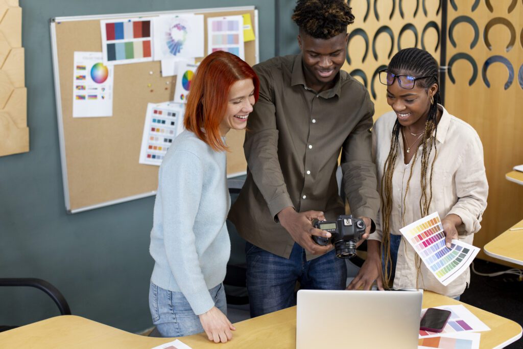 people working office medium shot – VidAU.ai Media team checking out an image taking with a camera before converting it to video with an ai photo to video generator